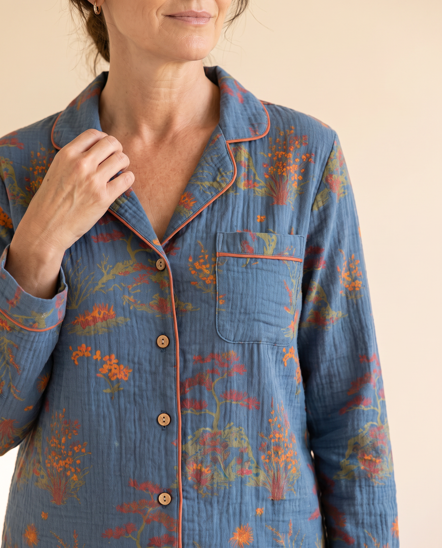 Close-up of Night Owl Pyjamas Oriental Bloom print in teal blue, with orange piping