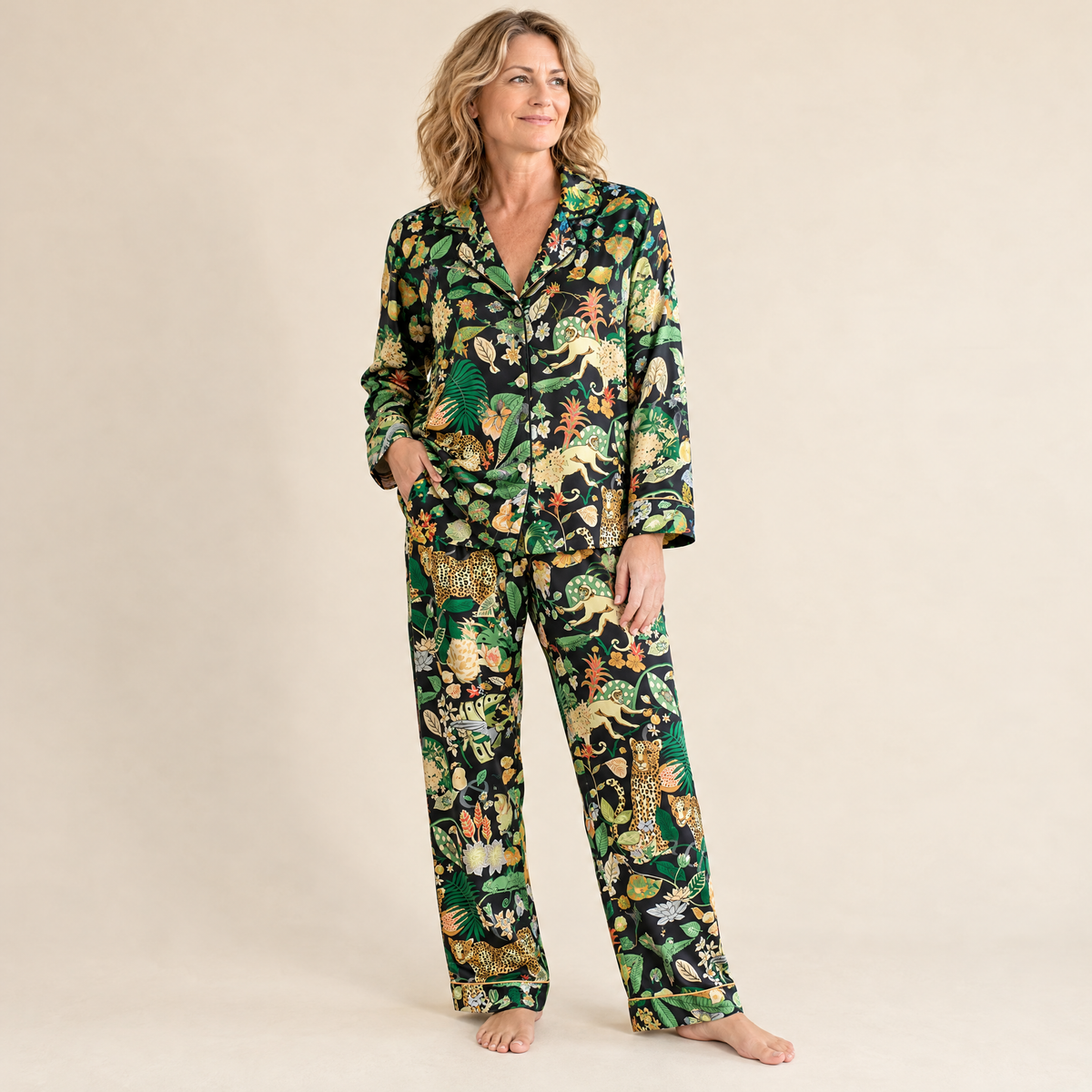 Woman wearing the Black Jungle Leopard long pyjama set in black satin with golden piping, full-length front view