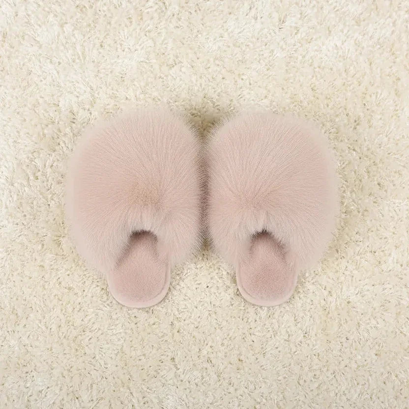 Night Owl Pyjamas blush pink plush faux fur pom pom slippers on a white fluffy rug